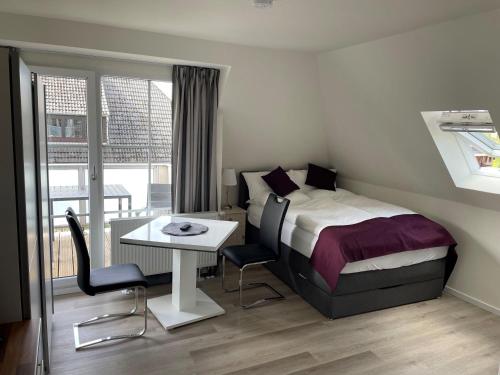 a bedroom with a bed and a desk and a table at Seaside-Amrum-10 in Norddorf