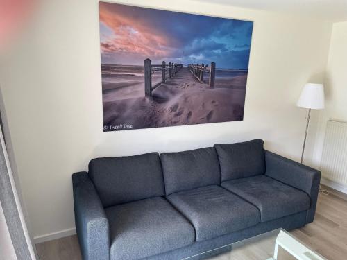 salon z kanapą i zdjęciem na ścianie w obiekcie Seaside-Amrum-13 w mieście Norddorf auf Amrum