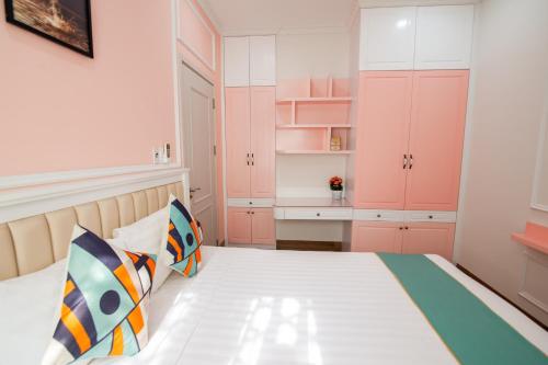 a small bedroom with pink cabinets and a bed at The View Hotel in Cam Lâm