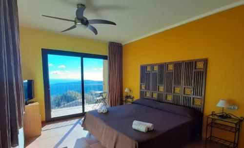 a bedroom with a large bed and a large window at Hotel Rural Cor De Prades in Mont-ral