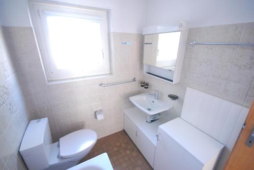 a bathroom with a white toilet and a sink at Lodola 298 3 Hk , Wohnung 3 in Lenzerheide