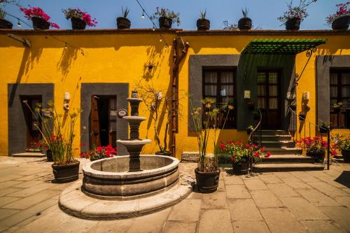 un edificio amarillo con una fuente frente a él en Collection O Al otro lado del rio, Puebla en Puebla
