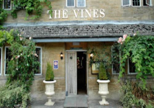 un bâtiment avec un panneau indiquant les vignes dans l'établissement The Vines Hotel, à Alvescot