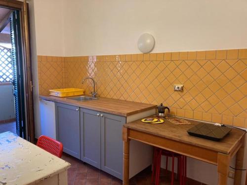 cocina con encimera, fregadero y mesa en Appartamento al 1° piano, zona centrale, en Fonteblanda