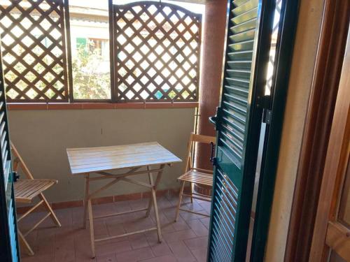 a table and chairs in a room with a window at Appartamento al 1° piano, zona centrale in Fonteblanda