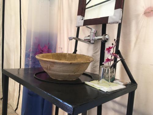 un tazón sobre una mesa negra con una batidora en Sahara Camp, en Adrouine