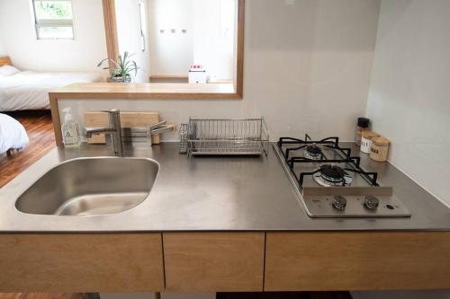 a kitchen with a sink and a stove at villa modama in Nanjo