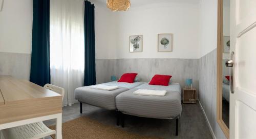 エリセイラにあるSurfer's Den Ericeiraのベッドルーム1室(赤い枕2つ付きのベッド1台付)