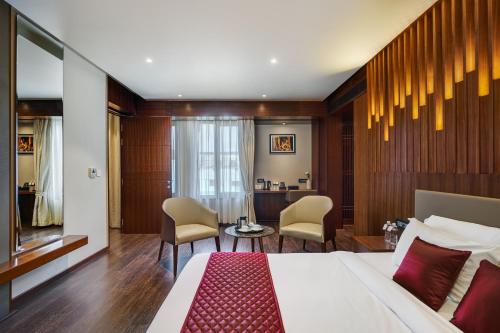 Pokój hotelowy z łóżkiem, krzesłami i biurkiem w obiekcie HOTEL ANS PRIDE Pudukkottai w mieście Pudukkottai