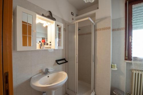 y baño blanco con lavabo y ducha. en Case Lanfranco Parma, en Parma