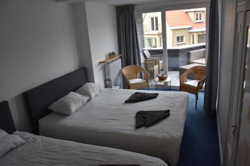a hotel room with two beds and a balcony at villa alice in Koksijde
