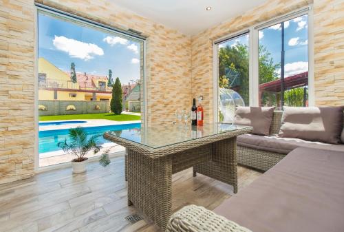 a living room with a glass table and a pool at Ponty-Papa Rendezvényház in Dávod