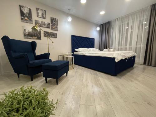 1 dormitorio con 1 cama y 1 silla azul en Krivenko 49 Str by Slissenko Inn, en Pavlodar