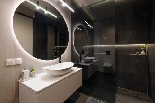 y baño con lavabo y espejo. en SKY Home- Sunset Penthouse -Neopolis, Centrum, Klimatyzacja, Parking Dostęp na Kod en Lodz