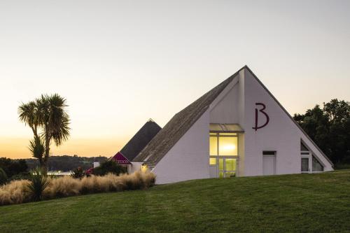 une église blanche avec un toit pointu sur une colline dans l'établissement Belambra Clubs Guidel - Les Portes De L'Océan, à Guidel-Plage