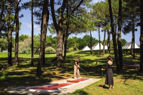 dos mujeres caminando por un parque con una cometa en Belambra Clubs Guidel - Les Portes De L'Océan, en Guidel-Plage