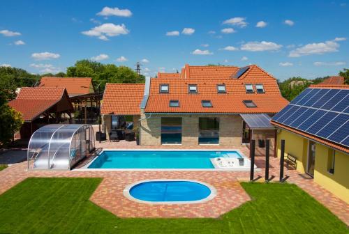 a house with a swimming pool and a house with solar panels at Ponty-Papa Rendezvényház in Dávod