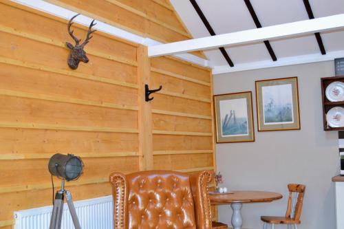 a room with wooden walls and a table and a chair at Arrowwood Self Catering (Wagtail and Nuthatch) in Kington
