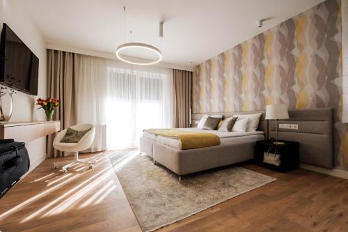 um quarto com uma cama, uma televisão e um sofá em Adele Apartments em Pécs