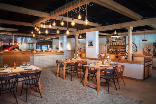 a restaurant with wooden tables and chairs and a bar at Victoria Hotel & Residence in Villars-sur-Ollon