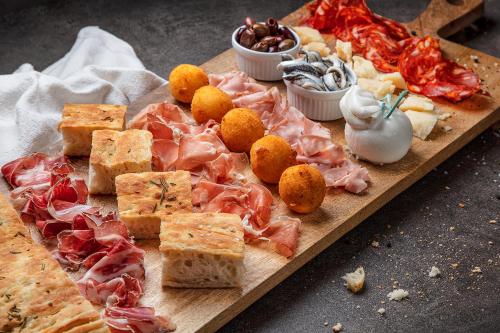 a plate of food with meats and cheese on a table at Victoria Hotel & Residence in Villars-sur-Ollon