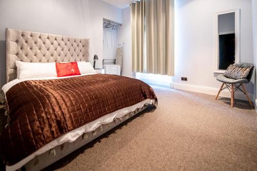 1 dormitorio con 1 cama grande y 1 silla en Jay's Apartment Aberdeen en Aberdeen