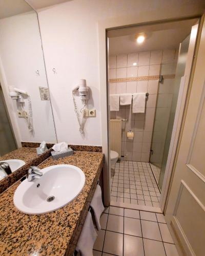 a bathroom with a sink and a shower at Parkhotel Kevelaer in Kevelaer