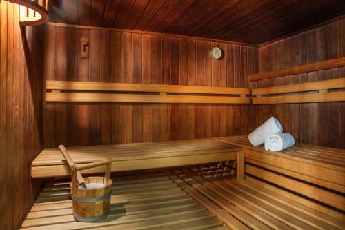 a sauna with a bench and a bucket in it at Victoria Hotel & Residence in Villars-sur-Ollon