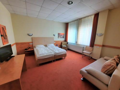 a hotel room with a bed and a couch at Parkhotel Kevelaer in Kevelaer