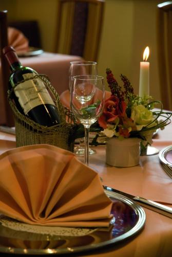a table with a bottle of wine and a candle at Parkhotel Kevelaer in Kevelaer
