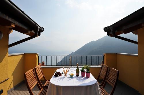 a table on a balcony with a view of a mountain at Borgo La Sorgente - Erica in Gravedona