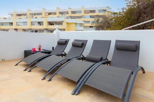 a row of chairs sitting on top of a patio at Villa Mar del Plata 8 bed apartment in Fuengirola