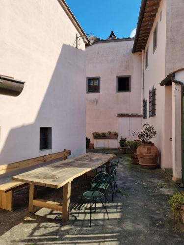a wooden table and chairs in the courtyard of a building at Podere Vecci in Dicomano
