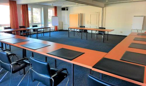a classroom with desks and chairs in a room at Parkhotel Kevelaer in Kevelaer