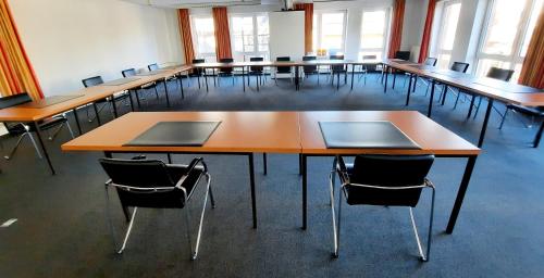 a classroom with rows of tables and chairs at Parkhotel Kevelaer in Kevelaer