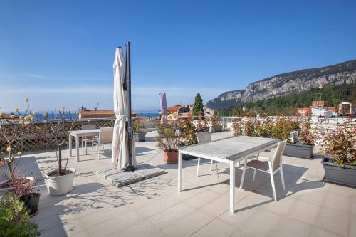 a patio with a table and chairs and an umbrella at LA ROCCA RELAX in Garda