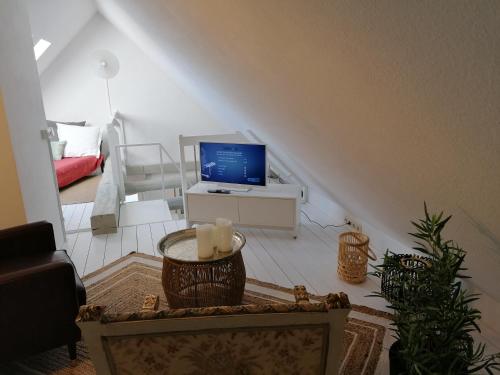 諾伊魯平的住宿－Loft "im Alten Pfarrhaus"，客厅配有电视和带蜡烛的桌子