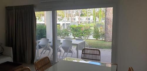 a dining room with a table and chairs and a window at Garden View 2 Dormitorios con Jardín y Parrillero hasta 7 personas in Punta del Este