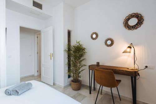Schlafzimmer mit einem Schreibtisch und einem Bett in der Unterkunft Magno Apartments Requena in Sevilla