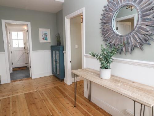 a living room with a table and a mirror at Belmont in Penzance