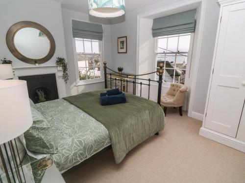 a bedroom with a bed and a mirror and a chair at Belmont in Penzance