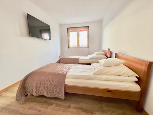 three beds in a bedroom with a television on the wall at Centrum Konferencyjne Brancon in Babimost