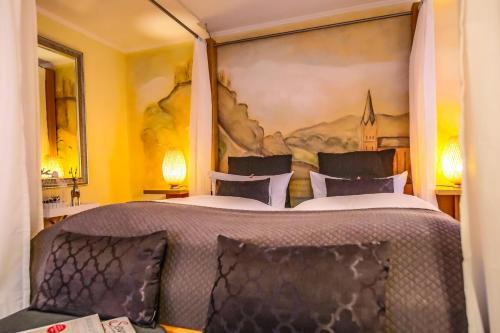 a bedroom with a bed with a large painting on the wall at Landhotel Zum Kronprinzen in Oberwesel