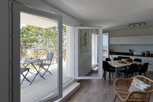 uma cozinha e sala de jantar com uma porta de vidro deslizante em Superbe appartement neuf face plage sur l ile de Noirmoutier em La Guérinière