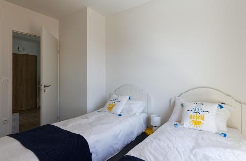 two beds sitting next to each other in a bedroom at Face à la mer - 50 m de la plage des homardiers in La Guérinière
