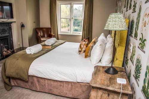 a bedroom with a large bed and a chair at The Swan Inn in Chiddingfold