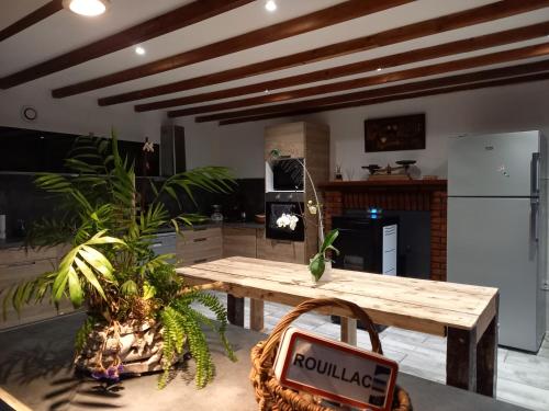 une cuisine avec une table en bois et un panneau. dans l'établissement Le Bonheur En Bretagne, à Rouillac