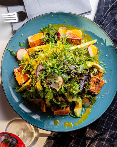 a blue plate with a salad on a table at Hotel Omega in Moers
