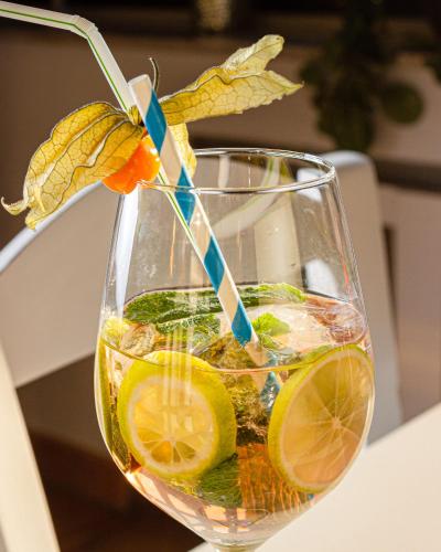 a glass vase filled with a drink with lemon slices at Hotel Omega in Moers