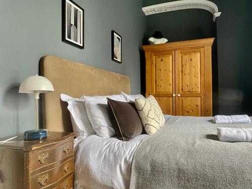 um quarto com uma cama e uma cómoda em madeira em The Georgian Manor Apartment - Central Frome em Frome